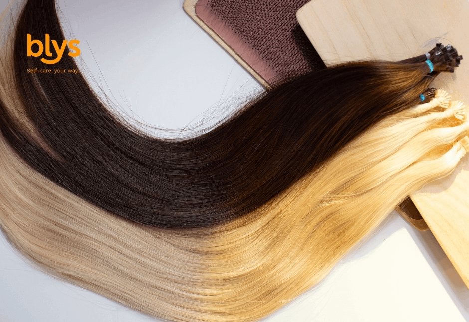 Close-up of a hairstylist adding hair extensions to blonde hair with a comb and clips, showcasing precise salon technique in a polished, professional setting.