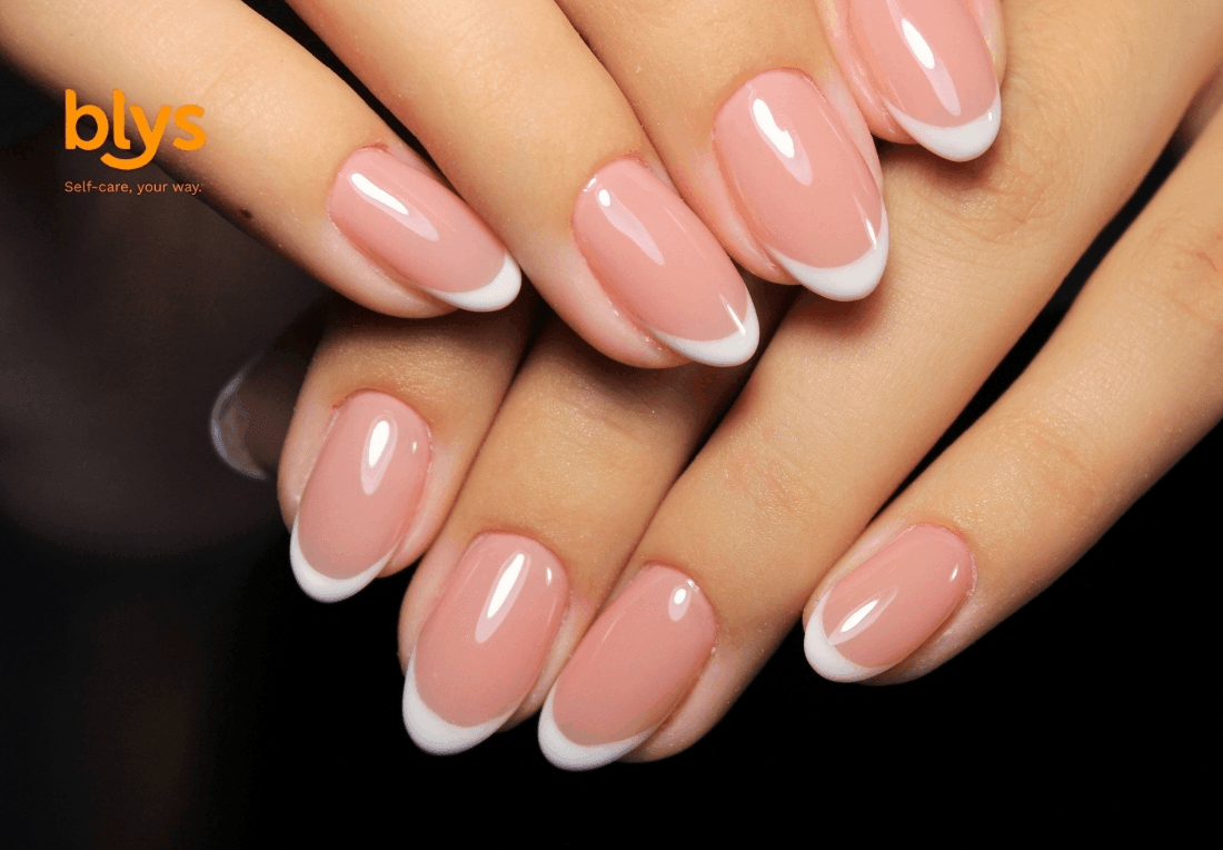 Close-up of manicured hands with glossy pink-and-white acrylic nails layered against a black background, conveying elegance and polish.