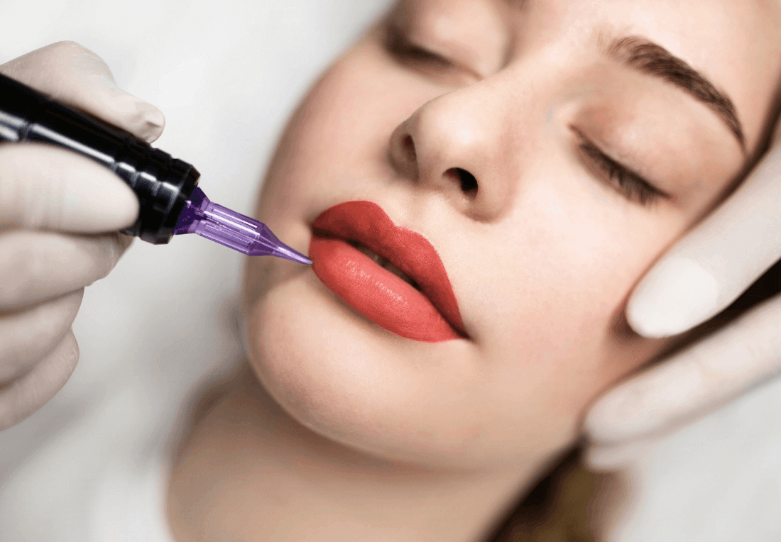 Close-up of a woman receiving cosmetic lip blush tattooing with a purple needle; gloved hands steady her face as red pigment is applied, creating a calm, clinical mood.